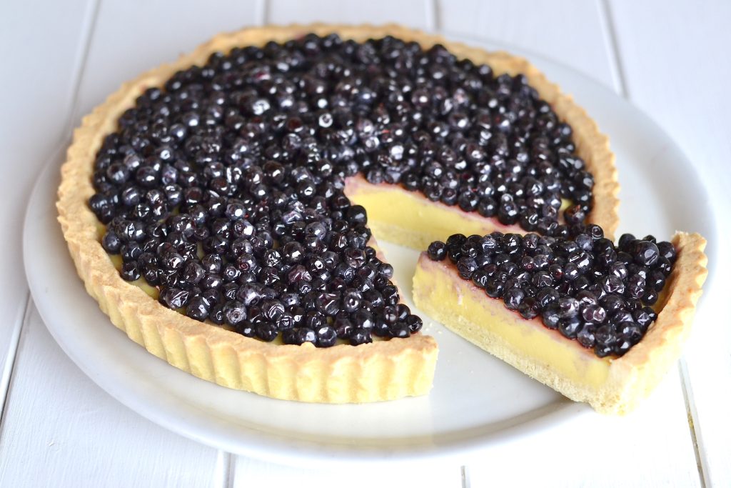 crostata con crema e mirtilli servita